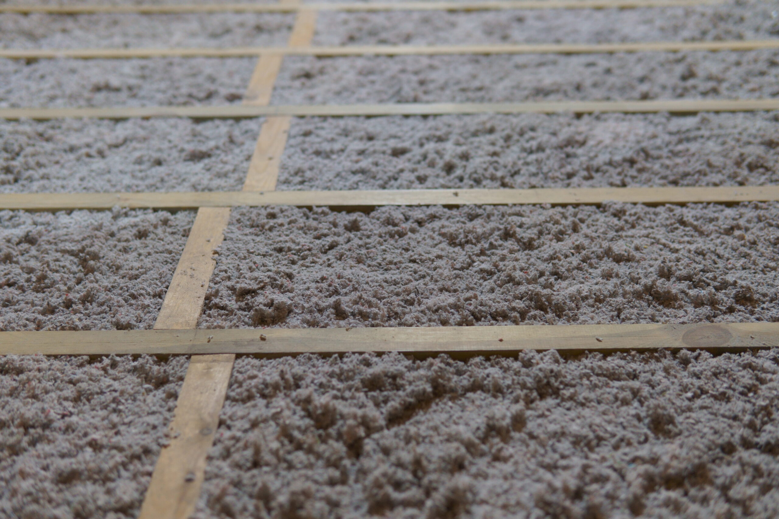 Grey cellulose insulation in wooden frames.
