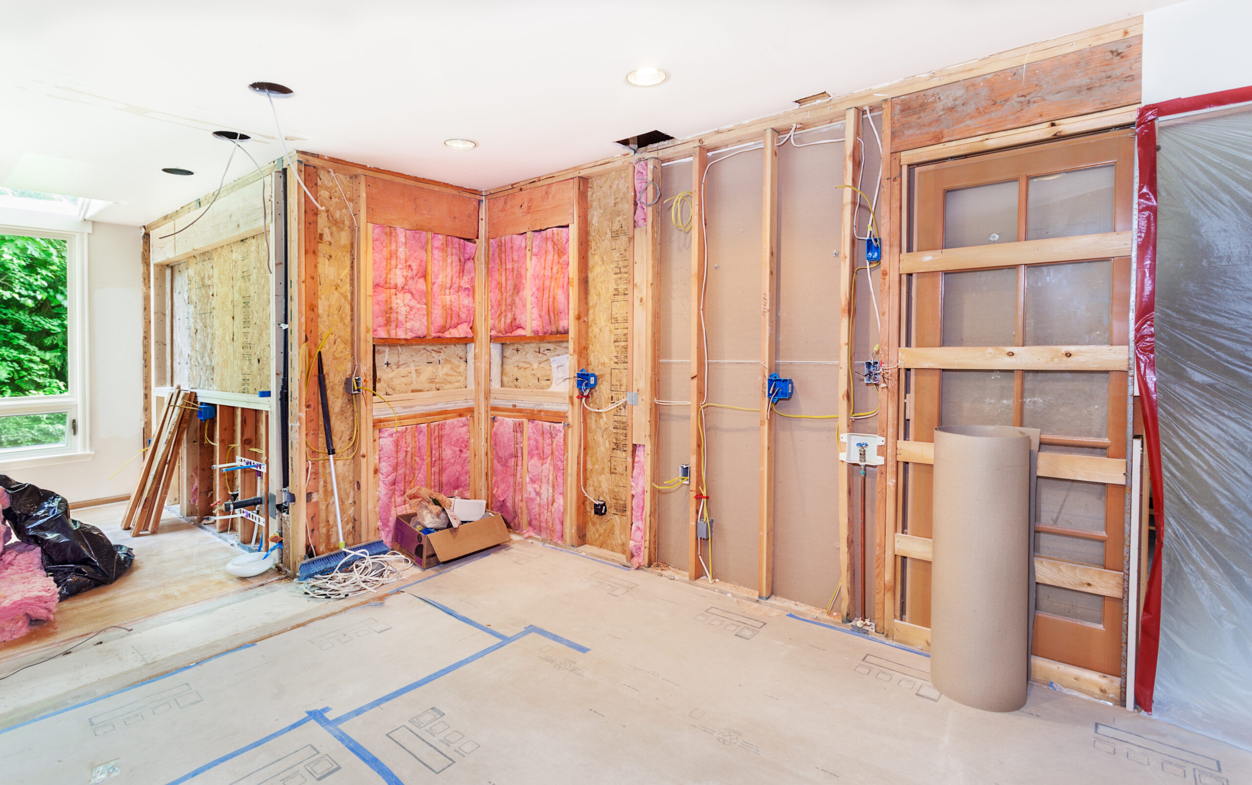 A home renovation in progress with pink fiberglass insulation visible in the walls.